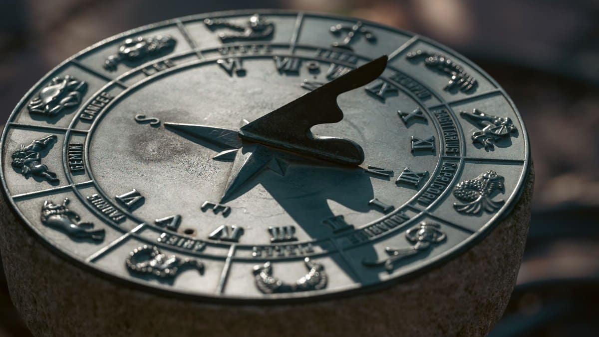 Detailed image of an antique sundial featuring zodiac symbols under natural light.