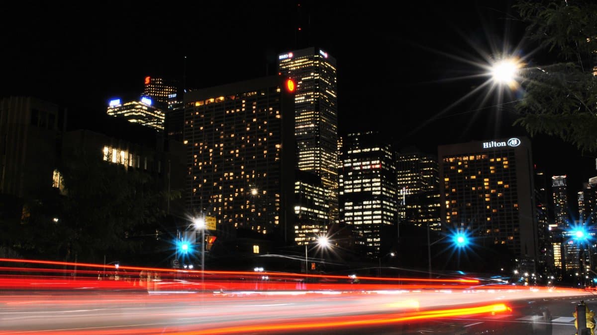 Dynamic urban night scene showcasing light trails against a lit city skyline.