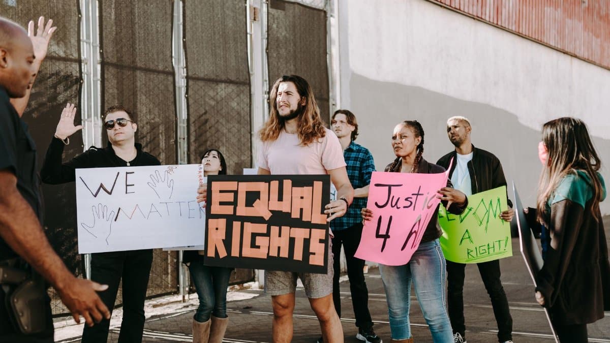 A group of diverse protesters holding signs advocating for equal rights during a peaceful street demonstration.