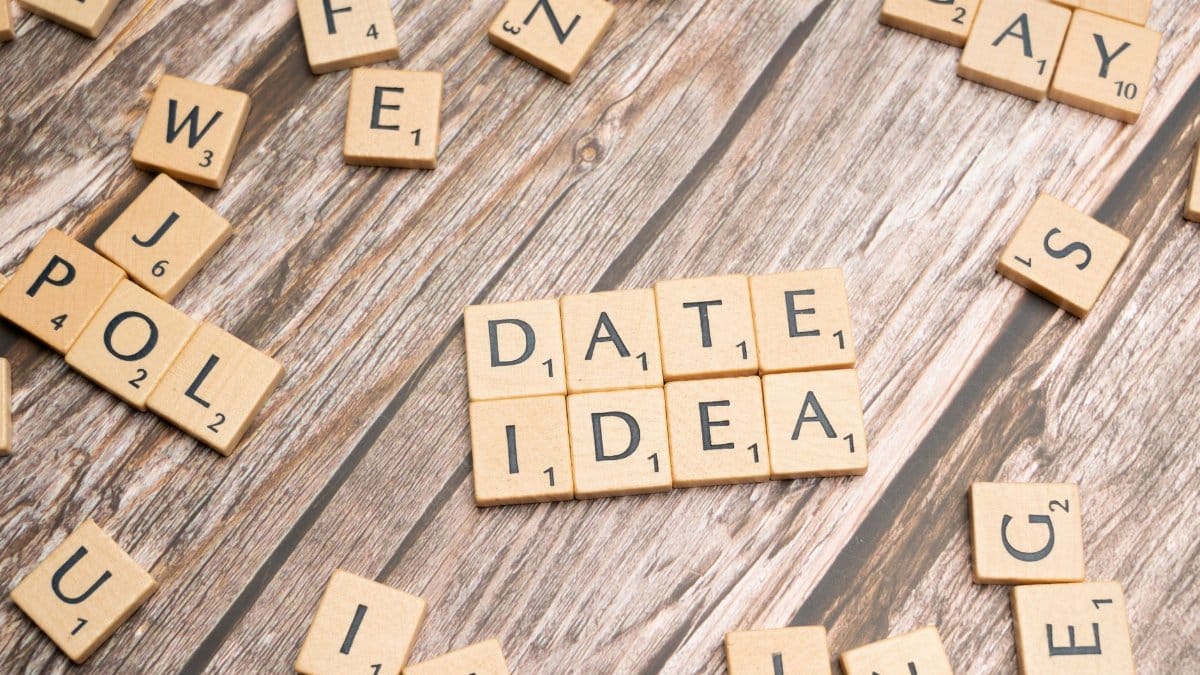 Letter tiles spelling 'Date Idea' on a wooden surface, suggesting creative meeting plans.
