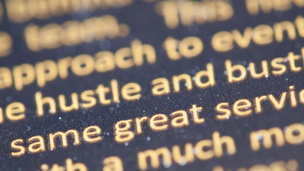 Macro shot of golden text highlighting typography on a dark background.