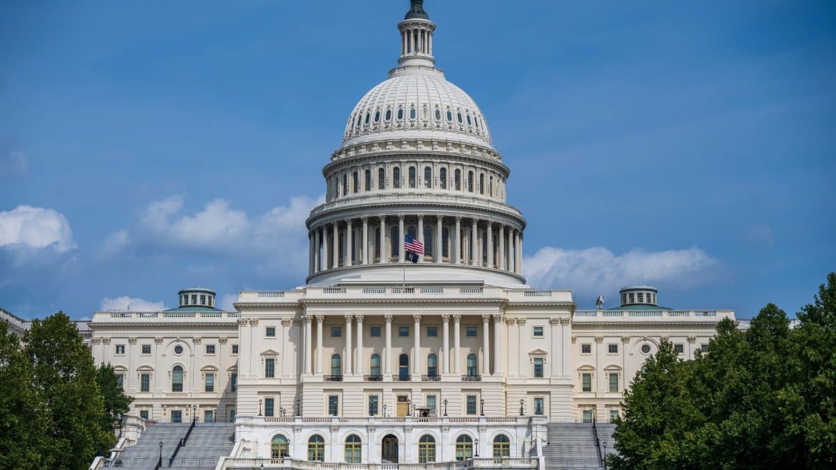 A frontal view of the iconic US Capitol Building in Washington D.C. under blue skies.