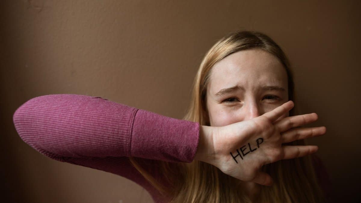 A woman with 'HELP' written on her palm. Emotion and assistance theme.