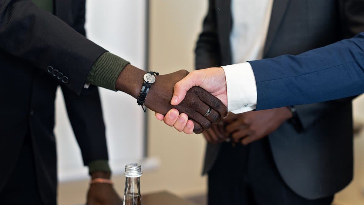 Close-up of a business handshake between two diverse individuals in formal attire.