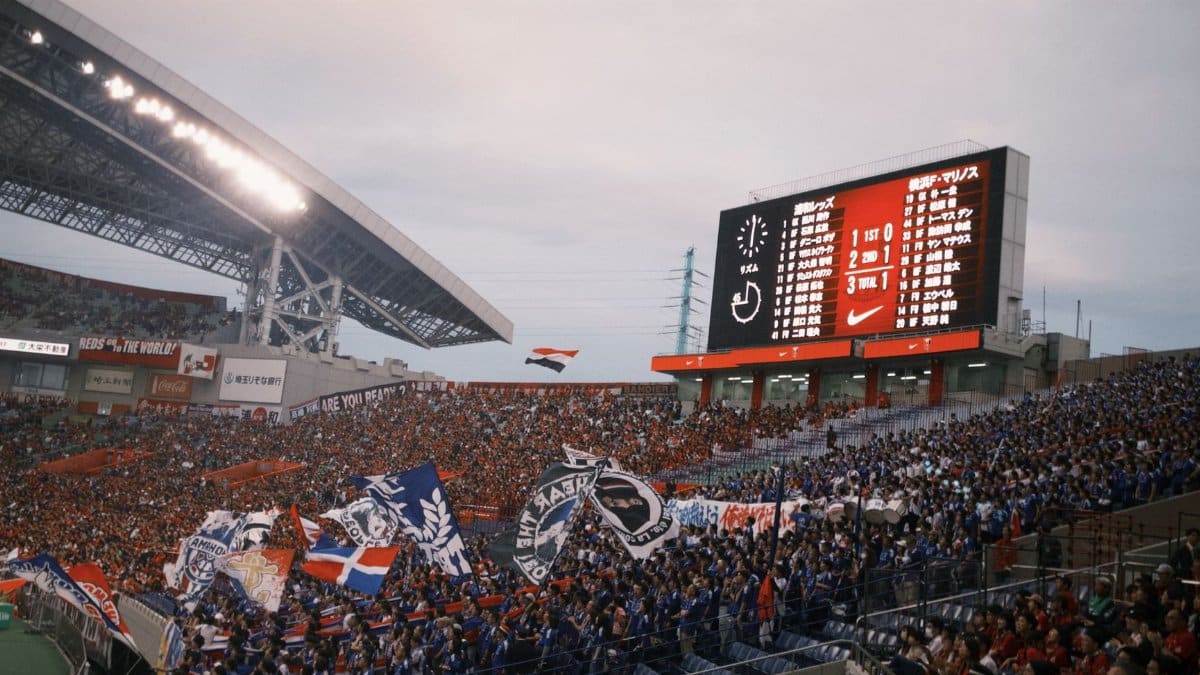 A vibrant soccer match with cheering fans at a packed stadium showcasing team spirit.