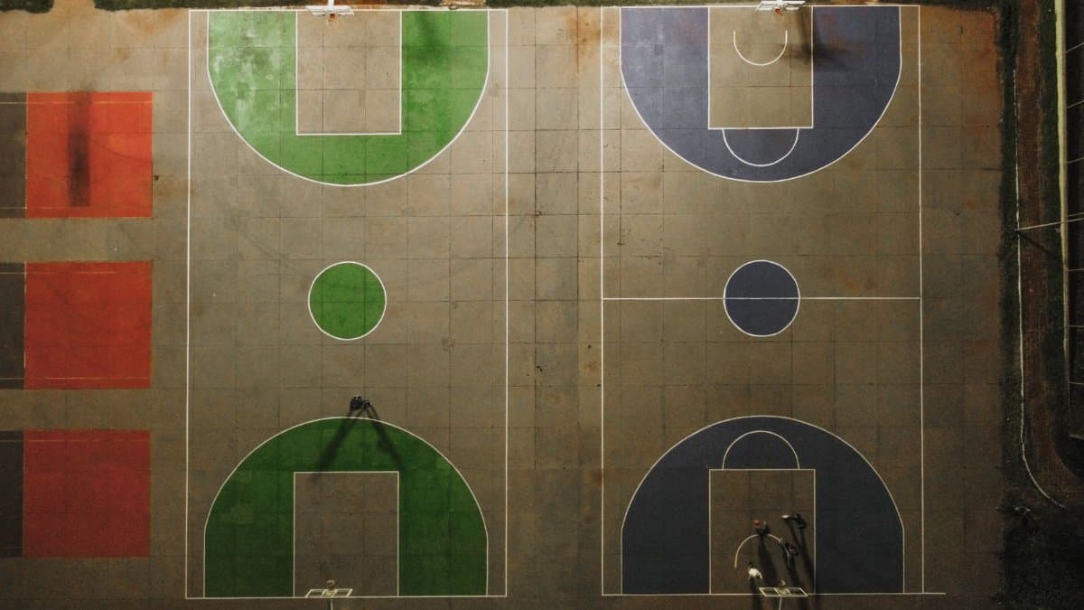 Top-down view of vibrant basketball courts at night in Brazil, showing detailed court markings.
