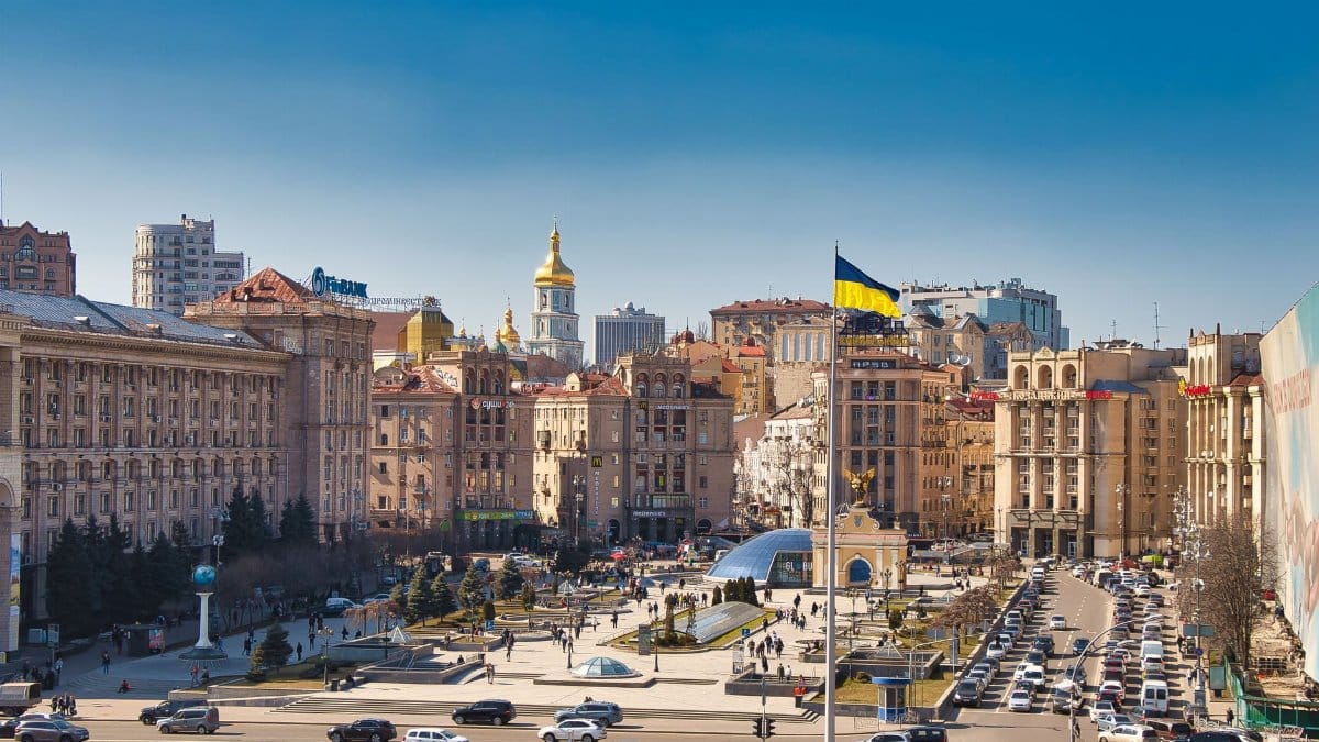 A bustling daytime scene at Independence Square in Kyiv, Ukraine, showcasing historical architecture and city life.