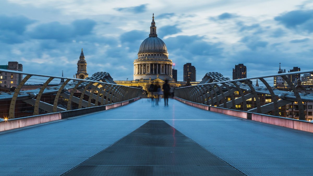 A striking shot of St Paul's Cathedral in London taken from Millennium Bridge at dusk, highlighting modern architecture.