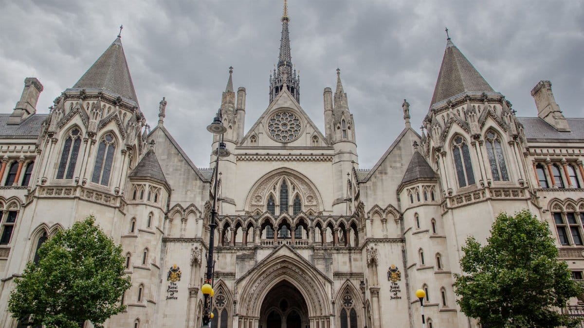 Exterior of the Royal Courts of Justice in London with cloudy skies.