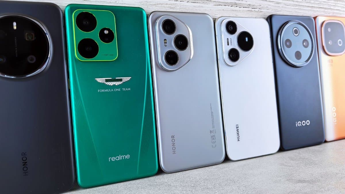 A collection of various smartphones lined up on a textured surface, showcasing different designs.