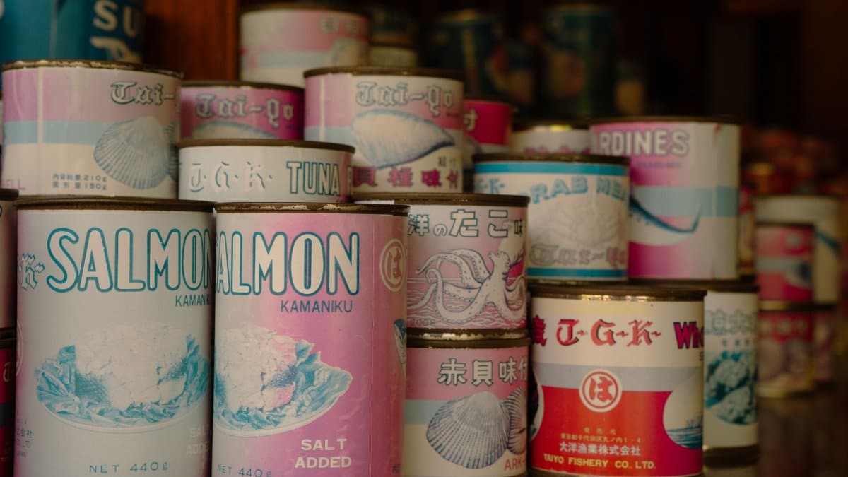 Vintage cans of Japanese seafood including salmon and tuna, displayed in a Tokyo shop.