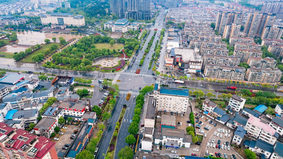Vibrant aerial view of urban landscape with greenery and modern architecture in China.