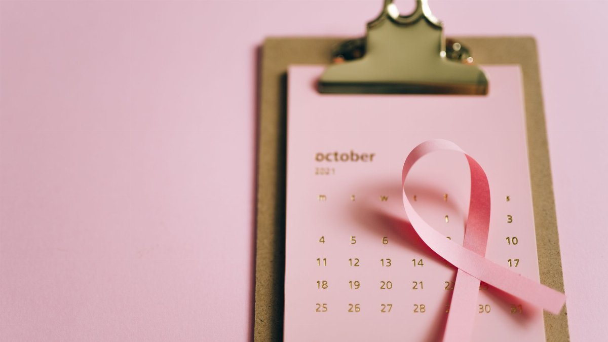 Pink ribbon on an October calendar symbolizing breast cancer awareness. Conceptual image promoting health awareness.