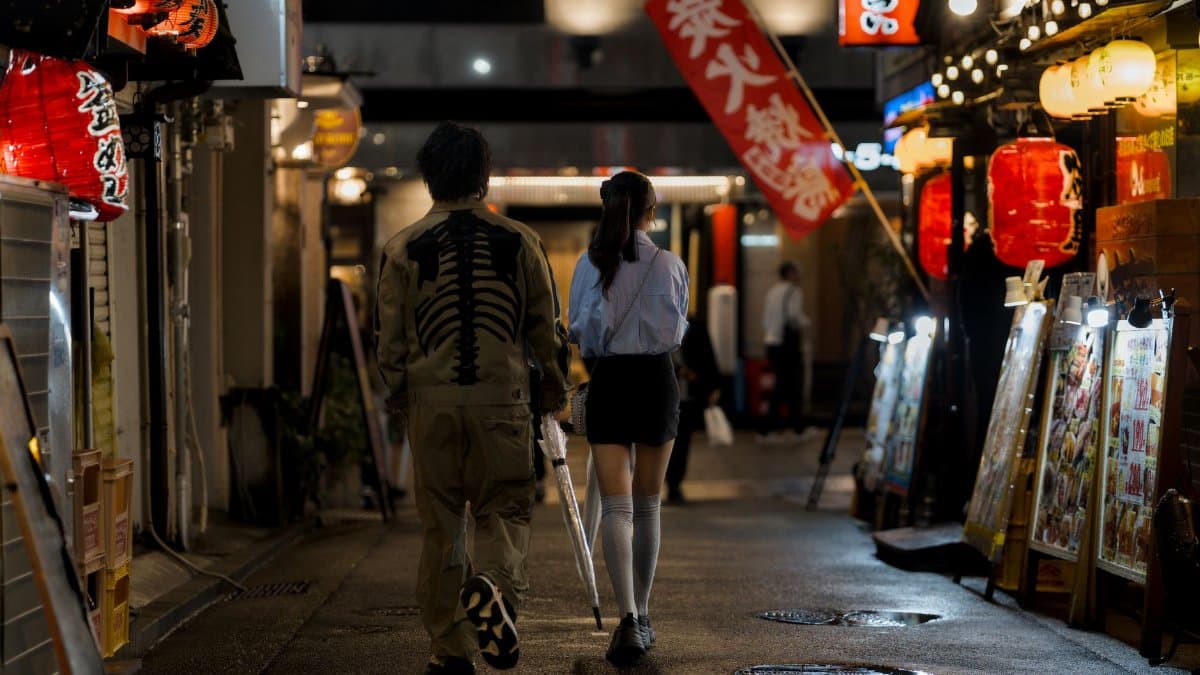 Couple walking past glowing lanterns in Kobe, highlighting Japan's nightlife.