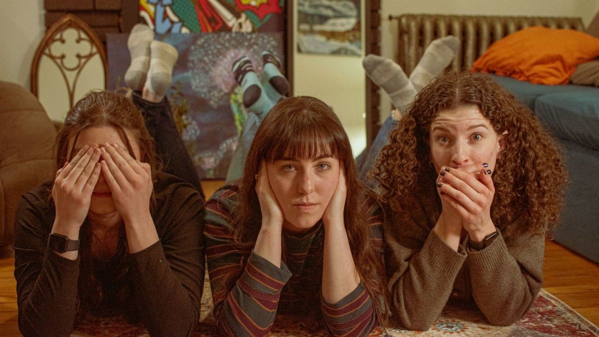 Three women simulate 'See No Evil, Hear No Evil, Speak No Evil' pose indoors.