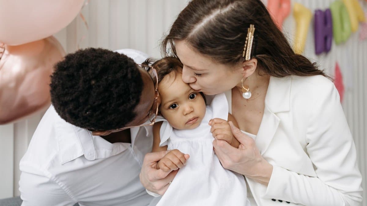 Loving parents sharing an affectionate moment with their child at a celebration.