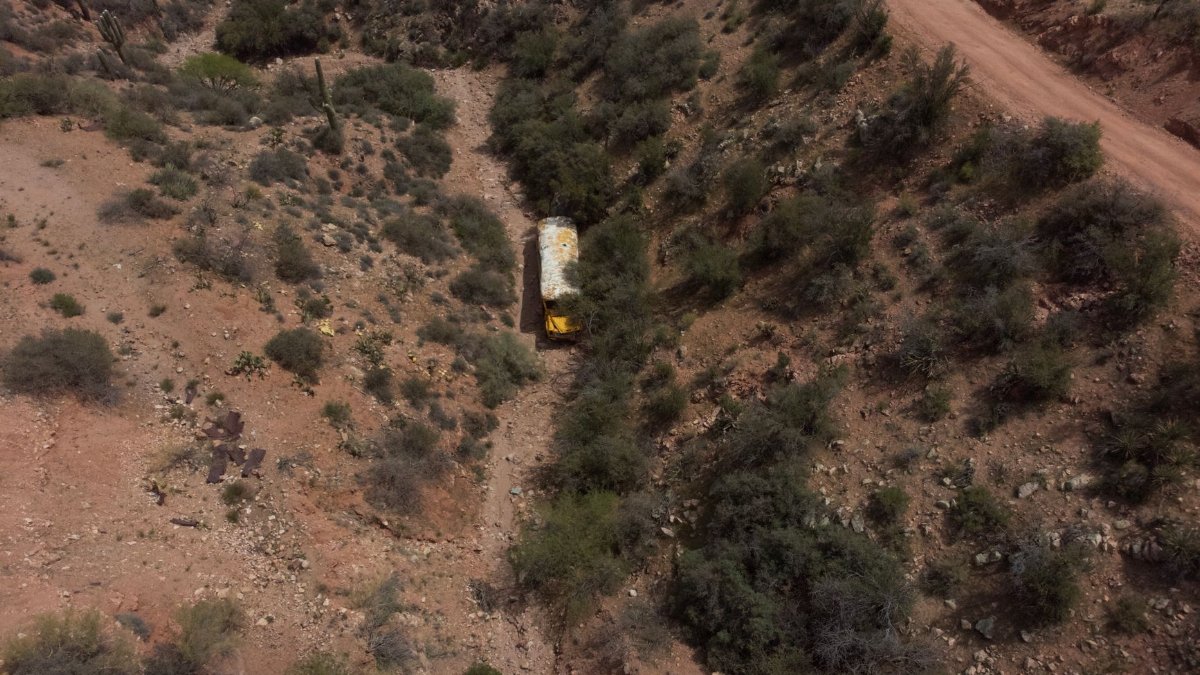 Aerial shot of an abandoned bus in the rugged desert terrain near Paxton Place, Arizona, USA.