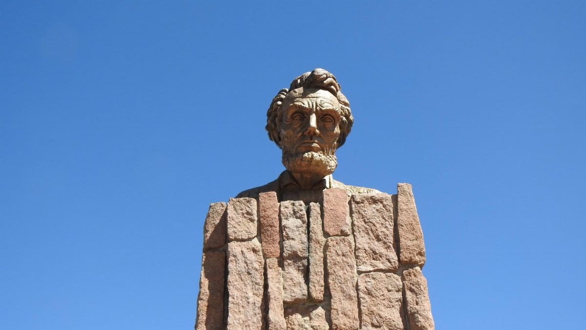 Bust of Abraham Lincoln at a Wyoming rest area against a clear blue sky.