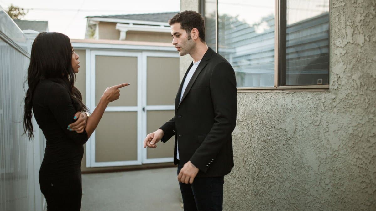 A tense moment captured between a man and a woman arguing outdoors.