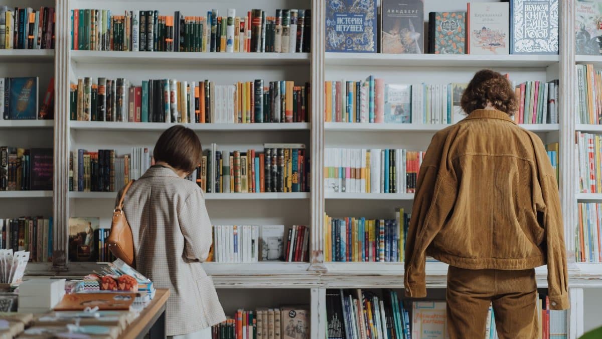 Two adults browsing books in a cozy bookstore, enjoying leisure time and self-education.
