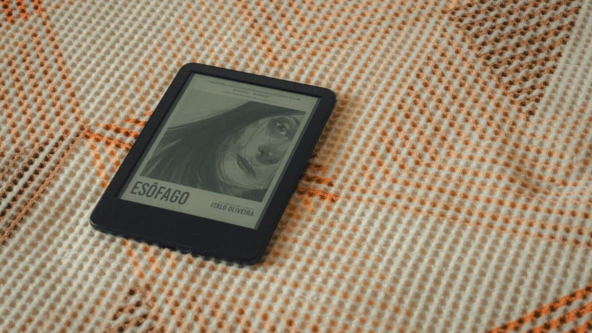 E-reader displaying a book cover resting on a cozy textured blanket.