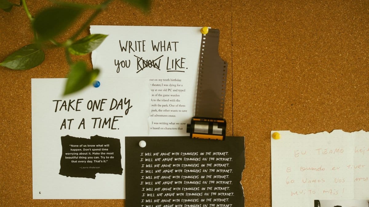 A corkboard with motivational quotes, notes, and film negatives, fostering creativity and reflection.