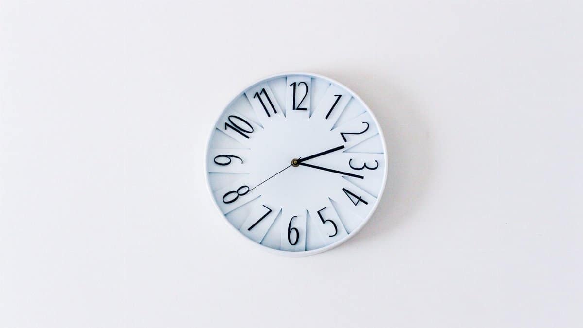 Simple minimalist wall clock on a white wall for a clean aesthetic.