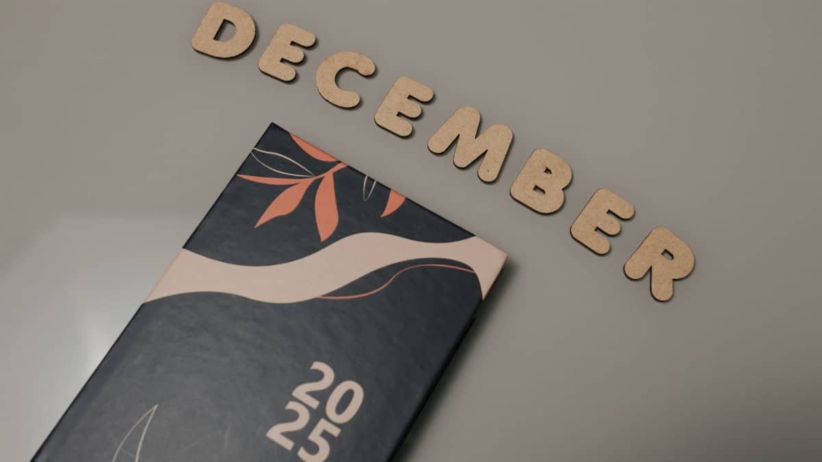 A 2025 planner displayed with wooden letters spelling 'December' on a neutral background.