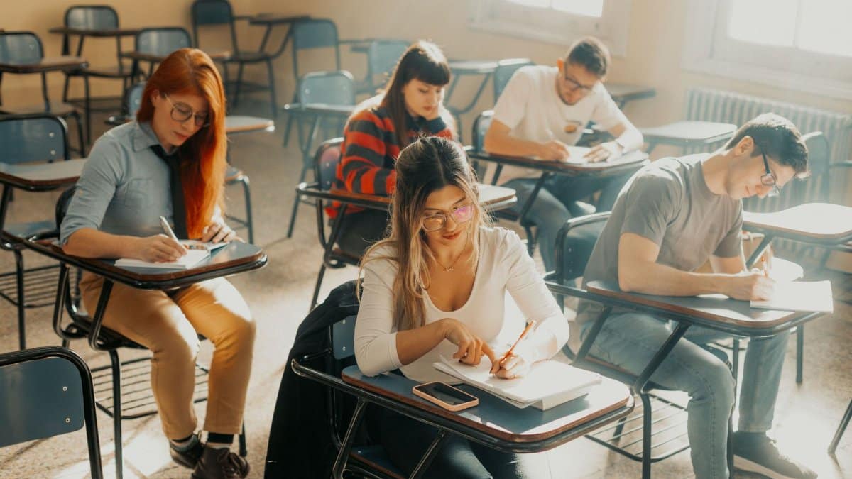 Group of students focused on writing during class in Buenos Aires classroom.