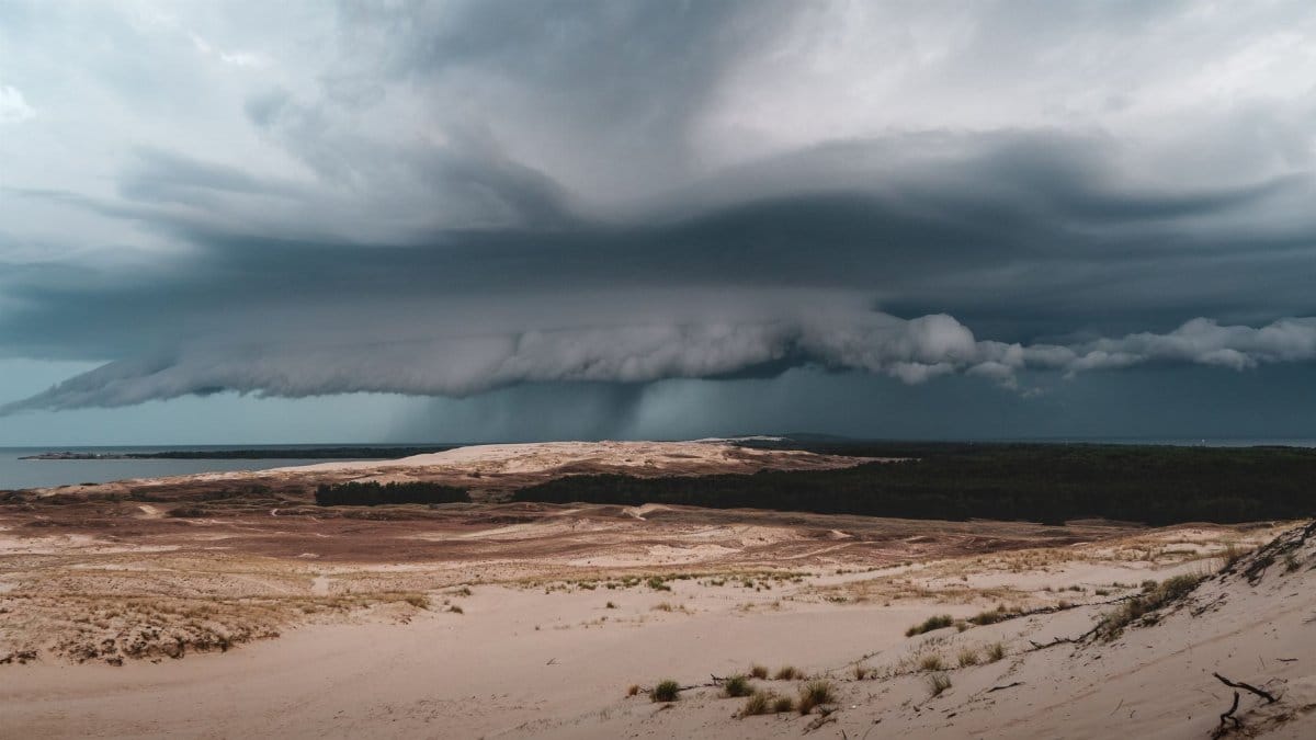 Capture of a dramatic sky over the dunes in Klaipėda County, Lithuania, with rain clouds looming.