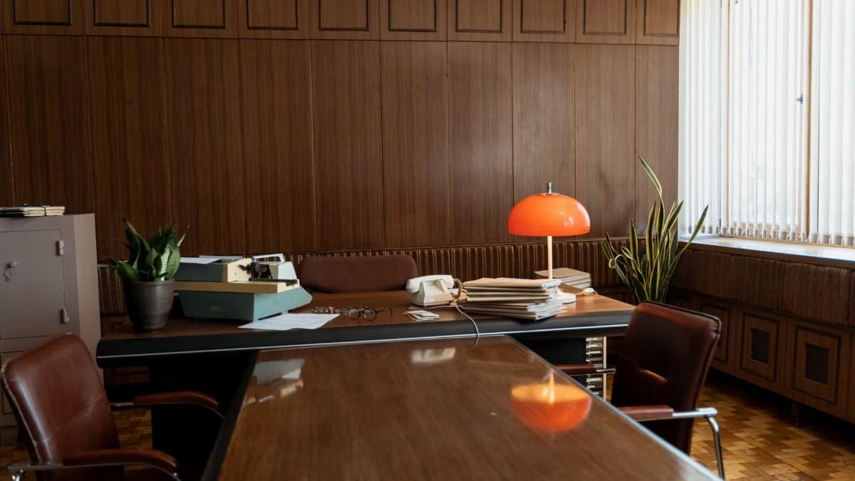 Vintage office setup featuring a typewriter, rotary phone, and retro furnishings.