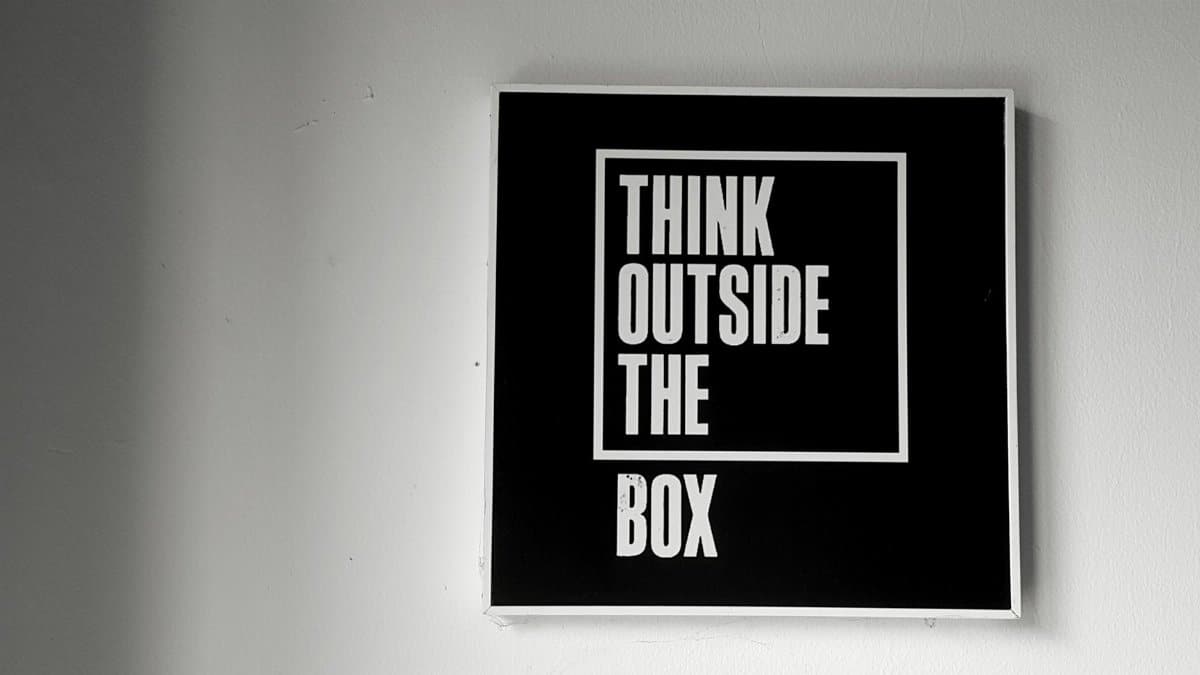 Black and white wall art with 'Think Outside the Box' message for creativity.