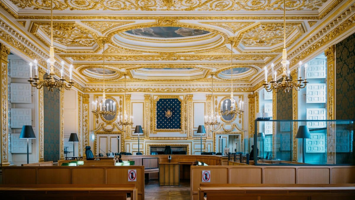 An ornate courtroom with golden details and chandeliers in Rennes, France.