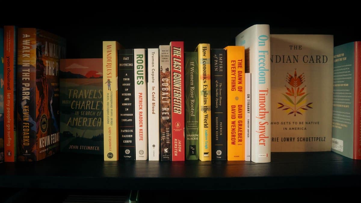 A well-stocked bookshelf featuring a variety of genres and authors.
