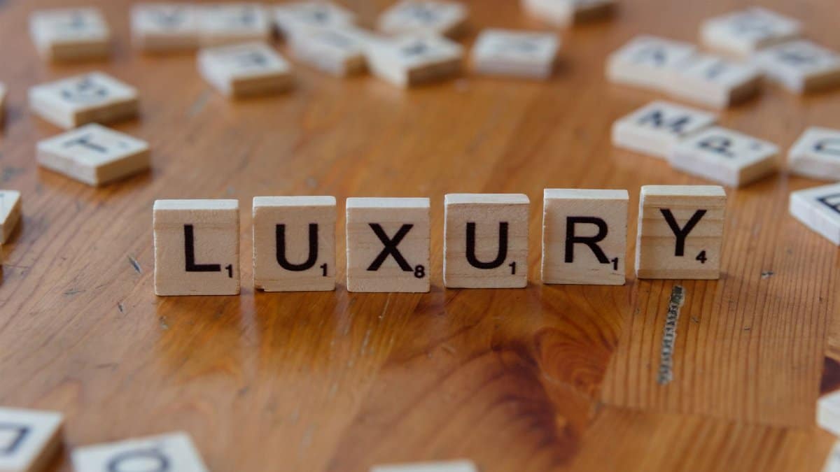The word 'Luxury' spelled with Scrabble tiles on a wooden surface, conveying elegance and wealth.