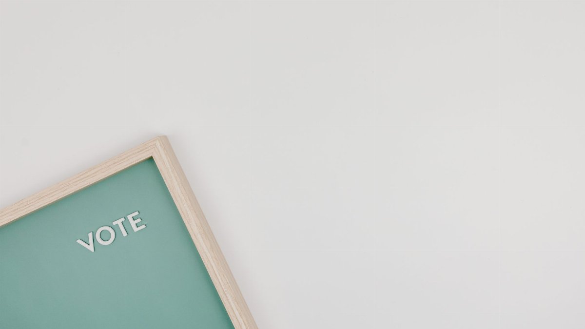 Minimalist letter board with VOTE text on a green background, perfect for election themes.
