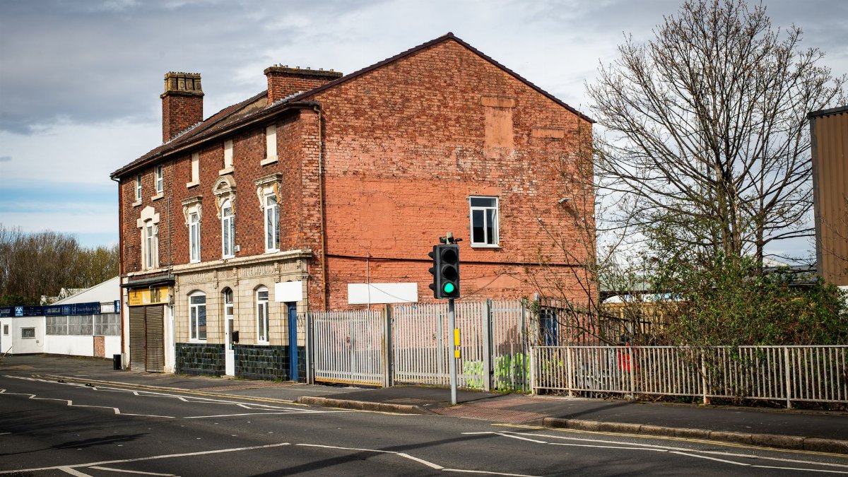 A vintage brick building with urban surroundings in Liverpool, UK, showcasing traditional architecture.