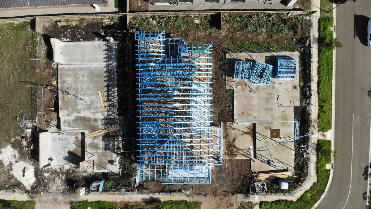 Aerial shot of a building construction site with blue framing structures.