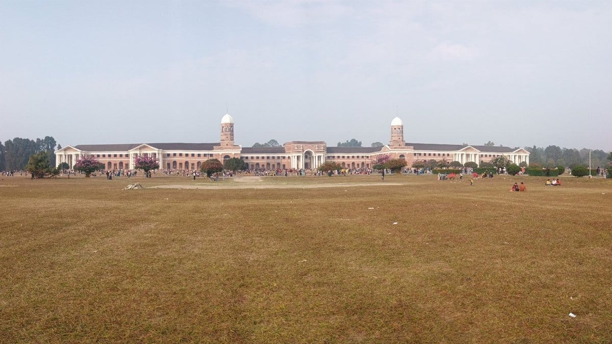 The grand facade of the Forest Research Institute in Dehradun, India, set against a clear sky.