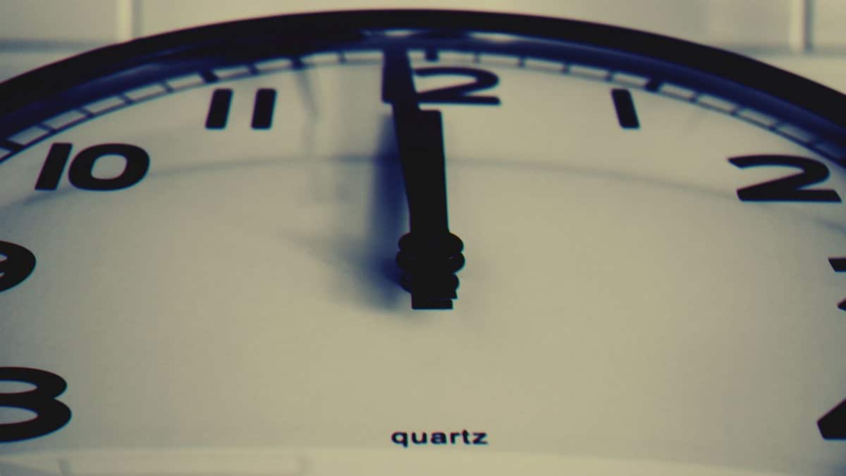 Detailed close-up shot of a wall clock showing the hour hand at midnight, highlighting time concept.