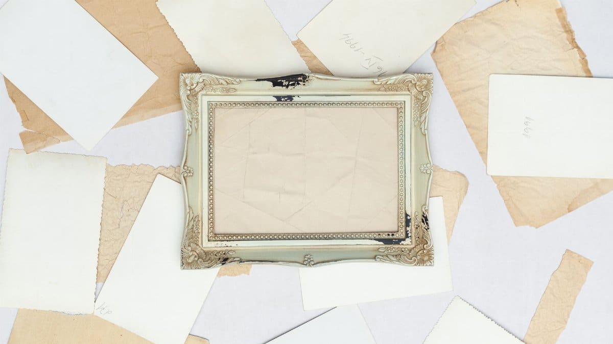 A vintage frame surrounded by various old papers on a white background, creating a nostalgic aesthetic.
