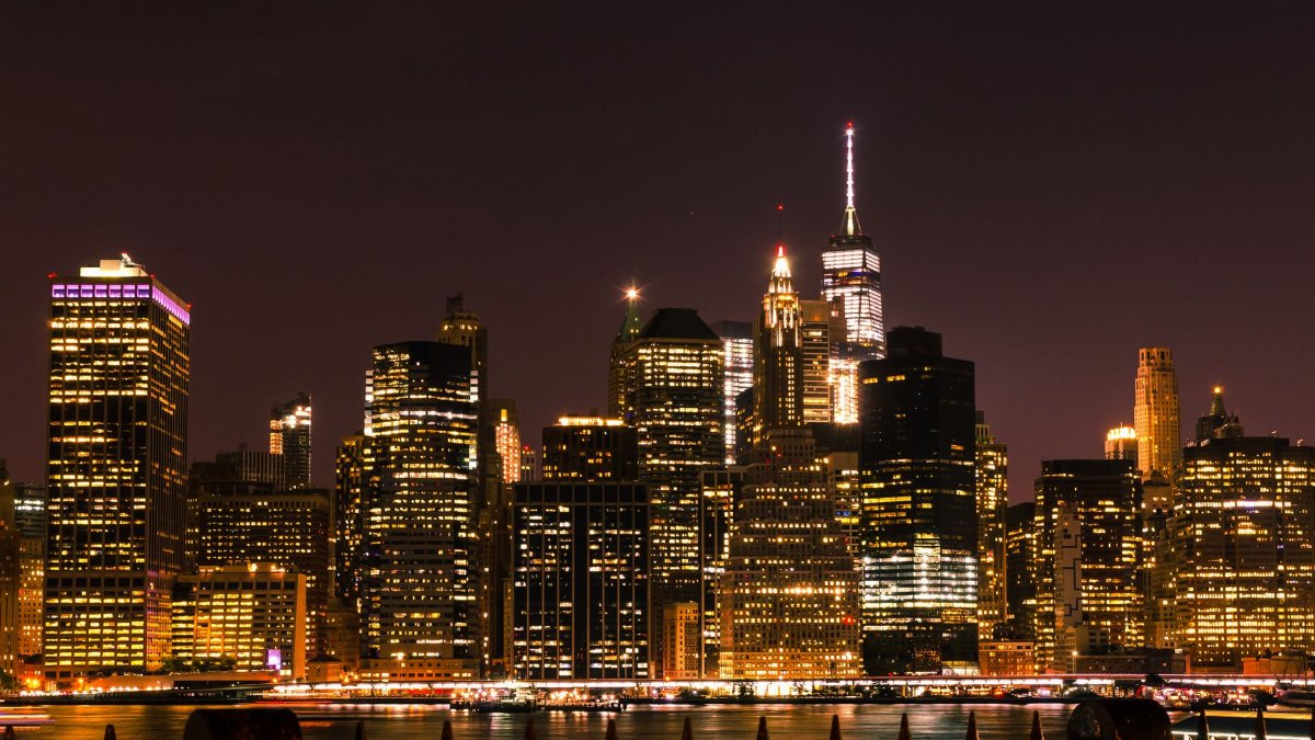 Illuminated New York City skyline at night showcasing iconic skyscrapers and city lights.