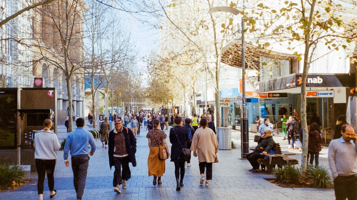 Crowds walking down a busy city street in Perth, Australia, during the day.