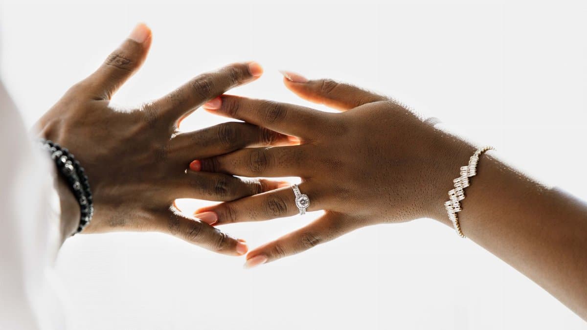 Elegantly styled hands wearing a ring and bracelet, symbolizing unity and commitment.
