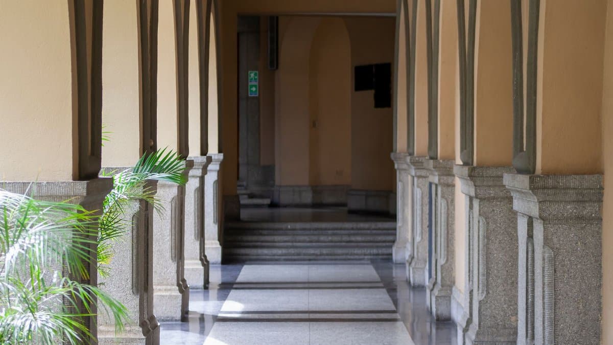 Sunlit colonial corridor in Venezuela with arches and columns casting beautiful shadows.