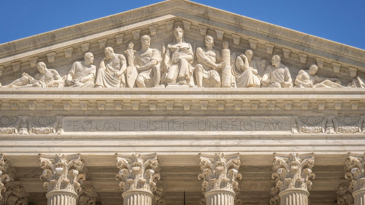 Detailed view of the Supreme Court Building's frontal frieze depicting historical figures and justices.