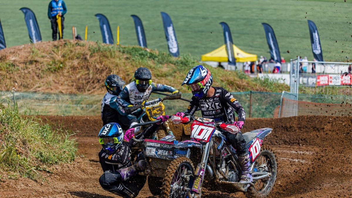 Dynamic sidecarcross race capturing the thrill of motorsport action on a dirt track.