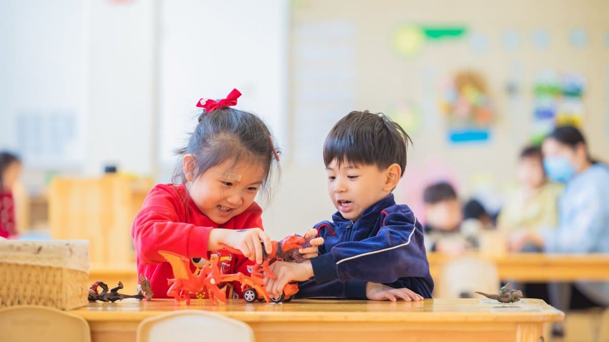 Two kids enjoy playing with toys in a lively kindergarten setting.