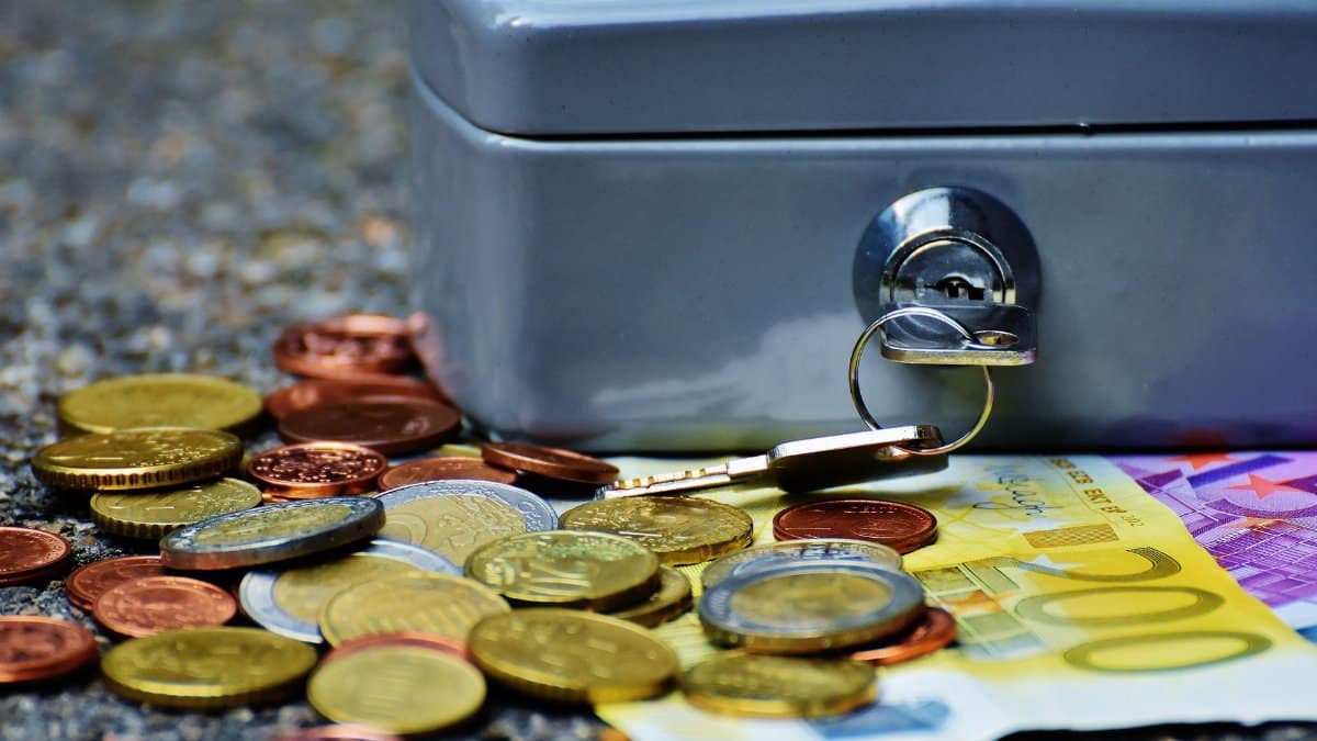 Close-up of a secure cash box with euro coins and banknotes, symbolizing wealth and financial security.
