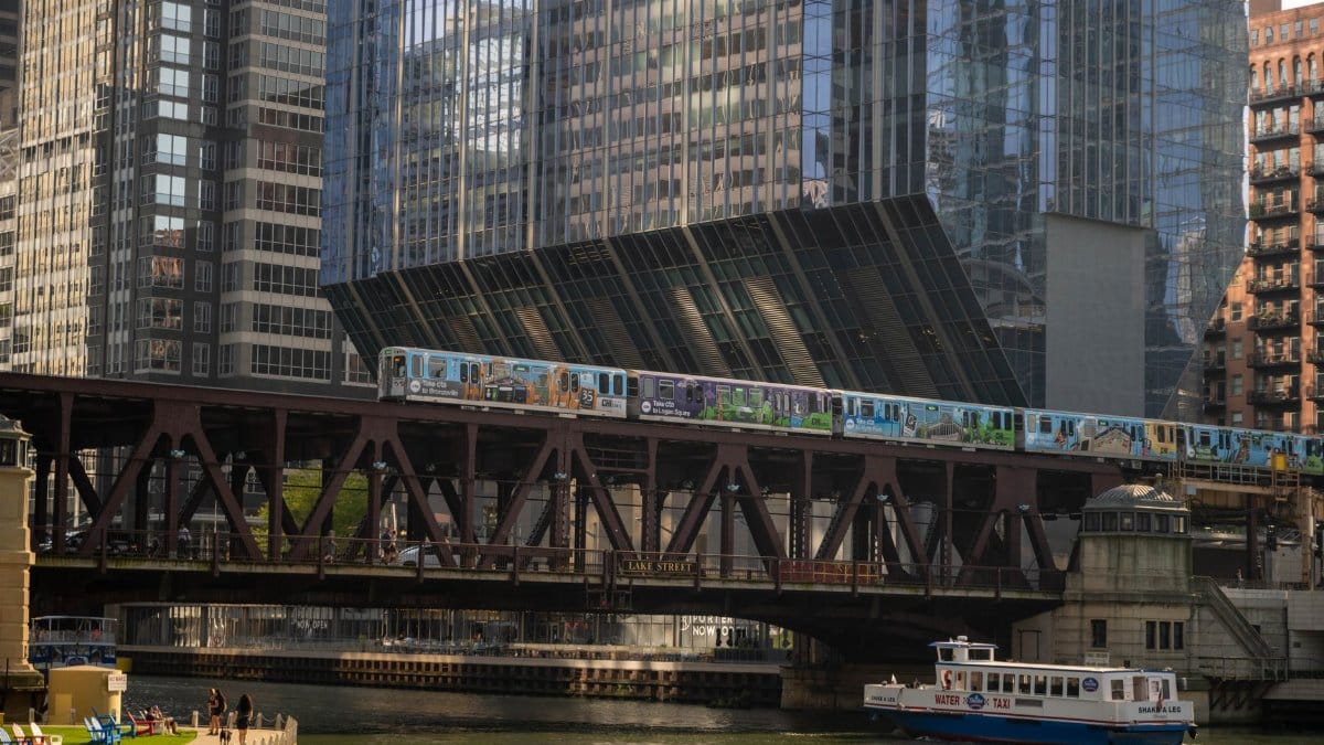 Vibrant urban scene of a river, bridge, and train in downtown Chicago.